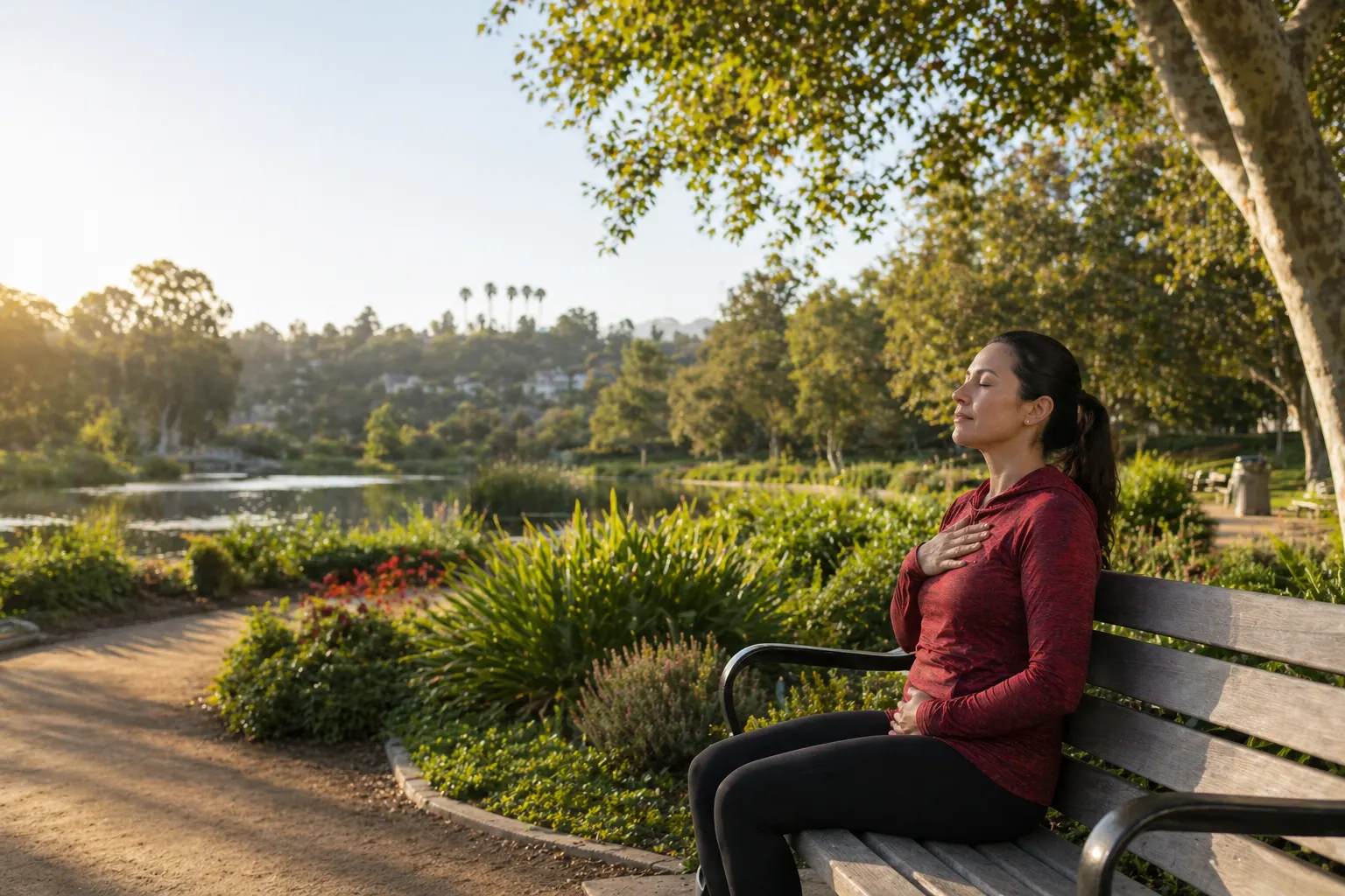 Woman practicing mindful breathing on a park bench near a lake